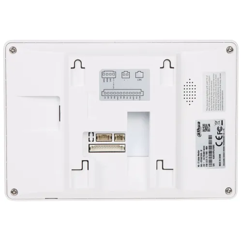 Zdjęcie przedstawia tylną część białego urządzenia elektronicznego z widocznymi portami i złączami, w tym portem LAN oraz złączami do montażu. Na obudowie znajdują się również etykiety z informacjami technicznymi i oznaczeniami producenta.