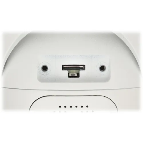 Zdjęcie przedstawia gniazdo na kartę pamięci oraz przycisk reset na białym urządzeniu elektronicznym. Widać również dwa otwory montażowe po bokach gniazda.