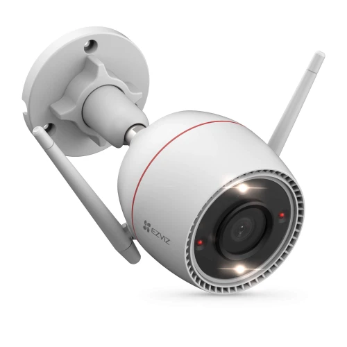 Na zdjęciu znajduje się biała kamera monitoringu z dwoma antenami, zamontowana na uchwycie ściennym. Kamera ma okrągły obiektyw otoczony diodami LED i logo producenta na obudowie.