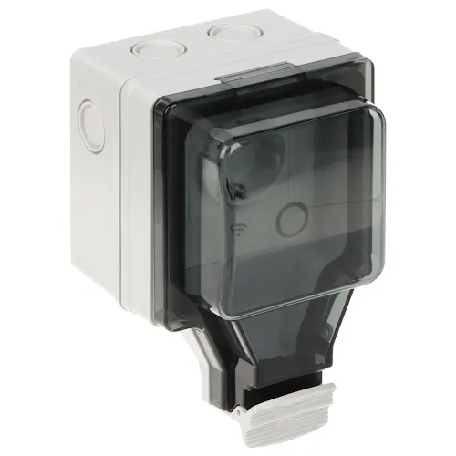 Na zdjęciu znajduje się inteligentne gniazdo elektryczne w białej obudowie z przezroczystą, ciemną osłoną ochronną. Gniazdo ma prostokątny kształt i jest przeznaczone do montażu na ścianie.