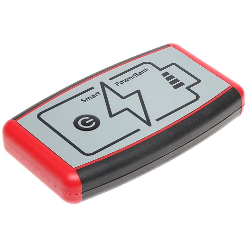 Na zdjęciu znajduje się przenośny power bank z czerwono-czarną obudową i szarym panelem z symbolami baterii i pioruna. Urządzenie ma zaokrąglone krawędzie i jest oznaczone jako "Smart PowerBank".