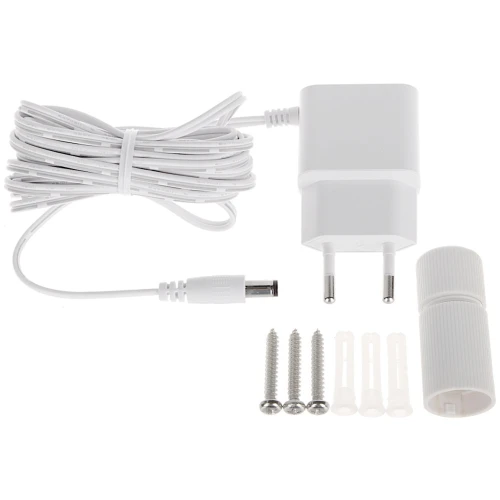 Na zdjęciu znajduje się biały zasilacz z długim kablem, zakończony wtykiem DC. Obok zasilacza leżą trzy śruby z kołkami rozporowymi oraz plastikowa osłona.