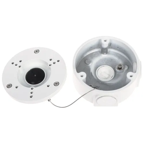 Na zdjęciu widać otwartą, okrągłą obudowę kamery monitoringu w kolorze białym, z widocznymi elementami montażowymi i metalowym wnętrzem. Obudowa jest podzielona na dwie części, z których jedna zawiera otwory na śruby i metalowy przewód zabezpieczający.