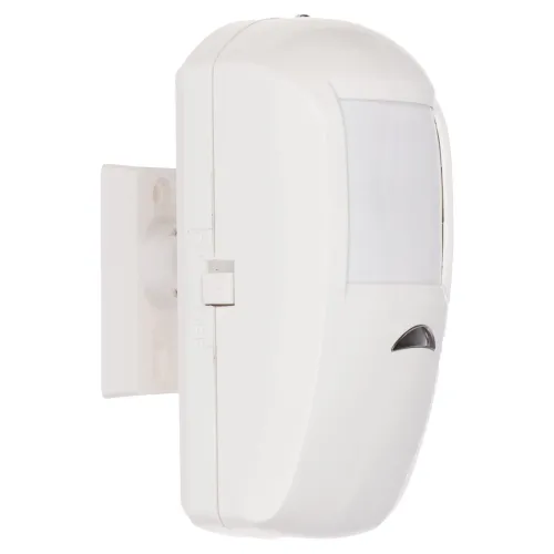 Biały czujnik ruchu z widocznym przełącznikiem on/off, zamontowany na uchwycie ściennym. Urządzenie ma zaokrąglony kształt i prostokątne okienko detekcyjne.