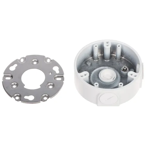 Na zdjęciu znajduje się okrągła, metalowa puszka montażowa z otworami, obok której leży metalowa płytka montażowa z kilkoma wycięciami. Puszka ma kilka wystających elementów wewnętrznych i jest przeznaczona do instalacji elektrycznych.