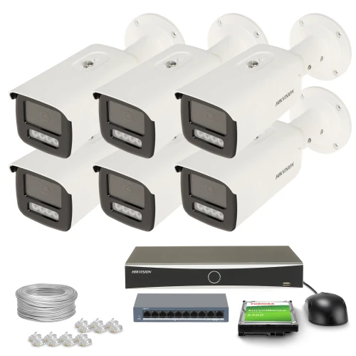 Zestaw do monitoringu składający się z sześciu białych kamer, rejestratora, kabla, przełącznika sieciowego, myszki oraz kart pamięci. Kamery są ułożone w dwóch rzędach po trzy, a pozostałe elementy zestawu znajdują się poniżej.