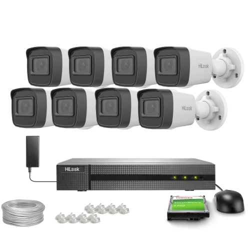 Zestaw do monitoringu składający się z ośmiu kamer, rejestratora, dysku twardego, zasilacza, kabla oraz złączek. Kamery są w kolorze czarno-białym, a rejestrator ma prostokątny kształt z widocznymi diodami LED.