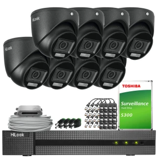 Zestaw do monitoringu składa się z ośmiu czarnych kamer HiLook, rejestratora, dysku twardego Toshiba S300 oraz akcesoriów montażowych. Elementy są ułożone na białym tle, prezentując kompletny system zabezpieczeń.