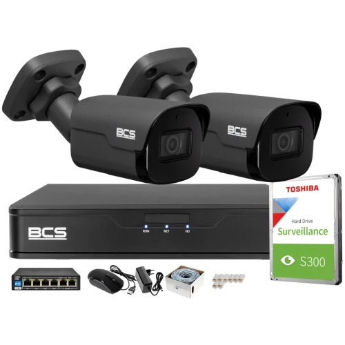 Zestaw monitoringu składa się z dwóch kamer BCS, rejestratora, dysku twardego Toshiba S300 oraz akcesoriów takich jak myszka, zasilacz, przewody i złącza. Kamery mają solidną obudowę, a rejestrator jest kompaktowy i elegancki.